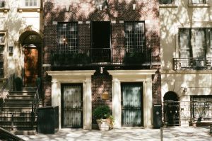 Two doors on a brick building with windows.